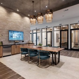 a clubroom with a table, chairs and a tv