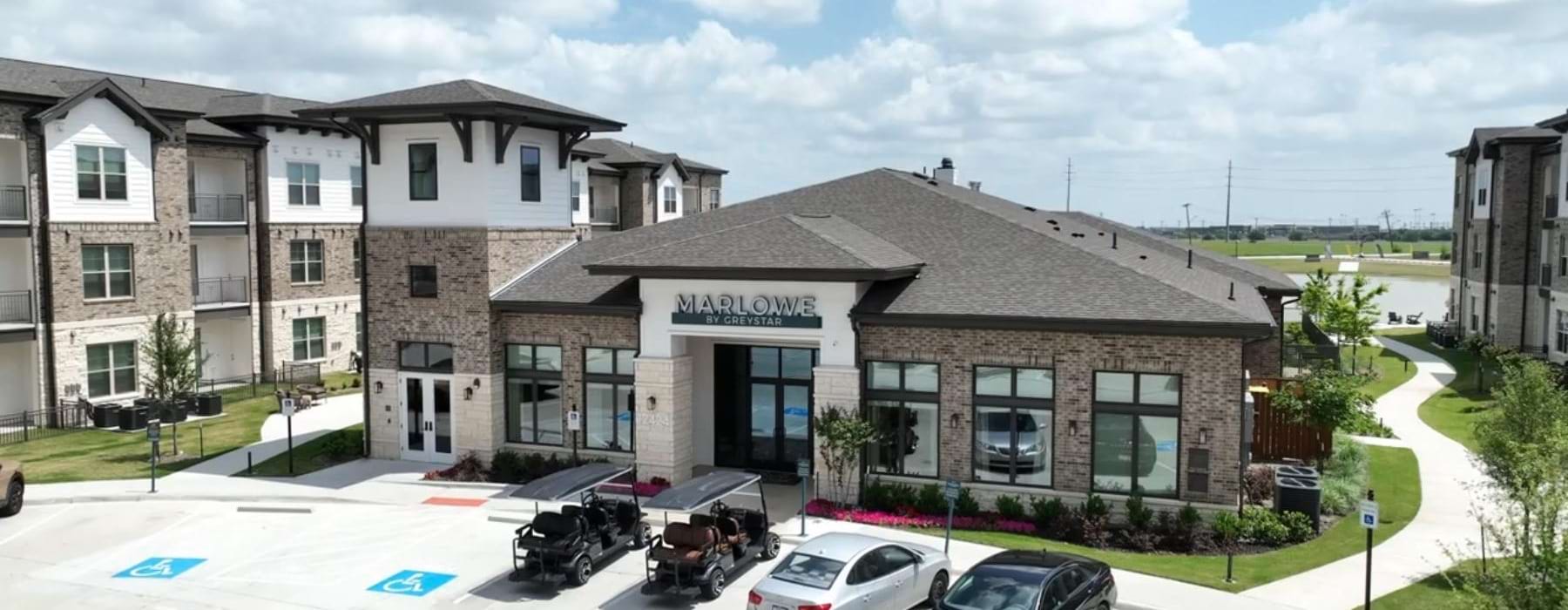 a leasing office with cars in a parking lot